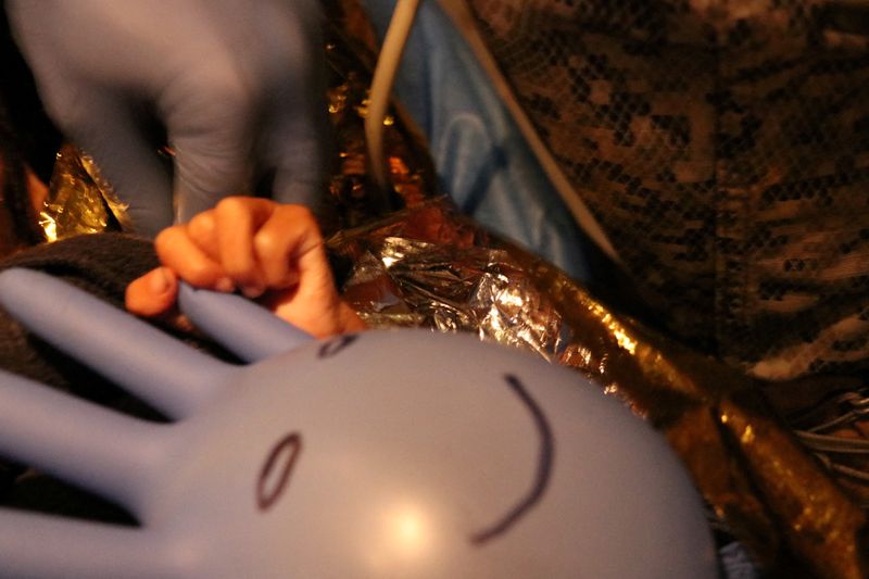 &copy; Reuters. FILE PHOTO: One of the surviving children from a Cessna 206 plane crash in the thick jungle, holds a surgical glove with a happy face drawn on it, while being transferred to Bogota via air in San Jose del Guaviare, Colombia, June 9, 2023. Colombian Air Fo