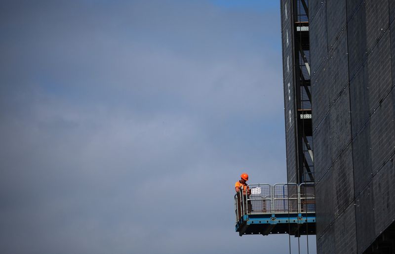 &copy; Reuters. FILE PHOTO: A construction worker stands on a platform on a new apartment building under construction in Manchester, Britain June 1, 2023. REUTERS/Phil Noble