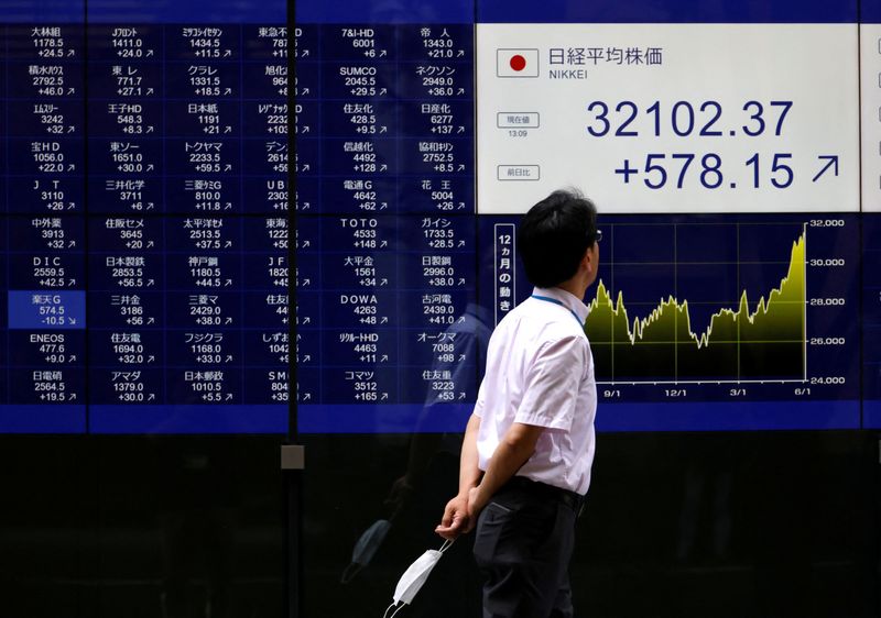 &copy; Reuters. FOTO DE ARCHIVO. Un hombre mira un monitor eléctrico que muestra una tabla de cotización de acciones fuera de un banco en Tokio, Japón. 5 de junio de 2023. REUTERS/Issei Kato