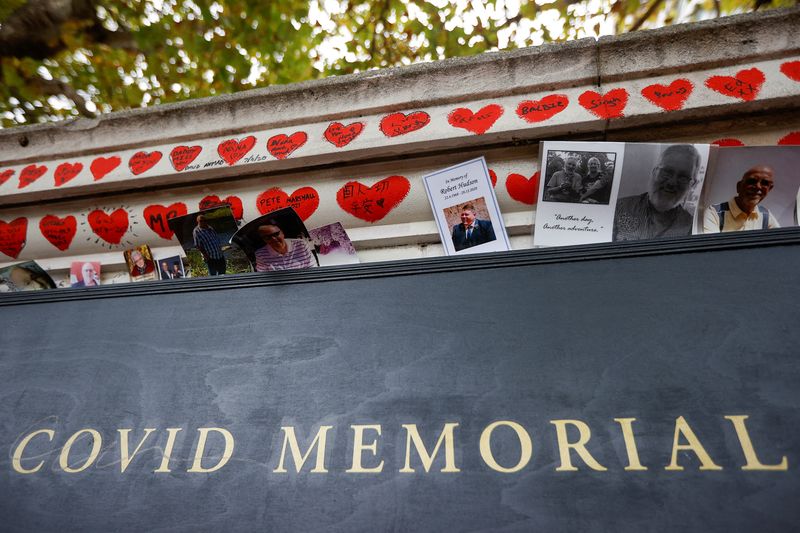 &copy; Reuters. FILE PHOTO: Photographs are left at the National Covid Memorial Wall, a dedication of thousands of hand painted hearts and messages commemorating victims of the COVID-19 pandemic, in London, Britain, October 4, 2022. REUTERS/Peter Nicholls/File Photo