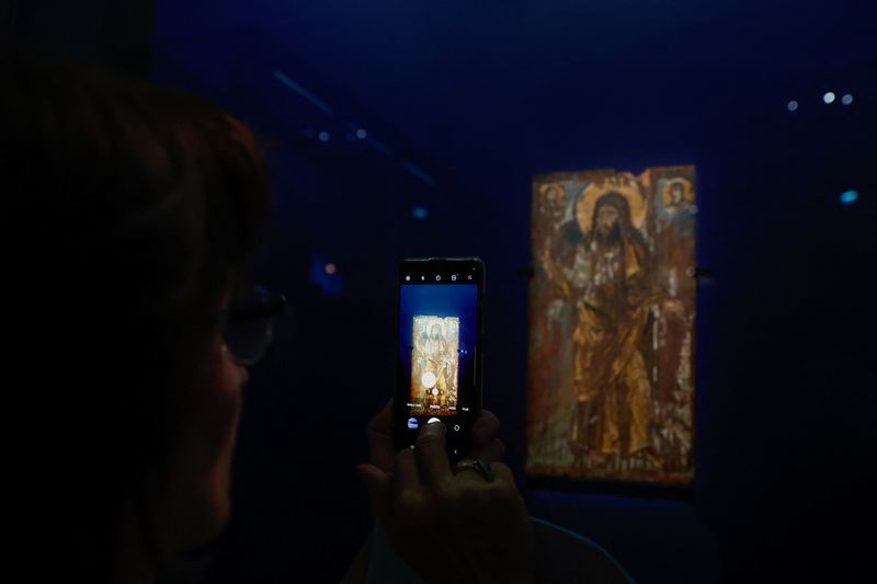 &copy; Reuters. Un periodista toma una fotografía de San Juan Bautista, pintura encáustica sobre tabla de madera del siglo VI, un raro icono bizantino de las colecciones del Museo Bohdan y Varvara Khanenko de Kiev, uno de los 16 iconos que fueron evacuados en el mayor 