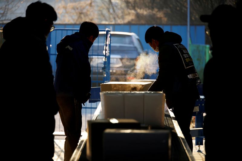 &copy; Reuters. FILE PHOTO: Parcel delivery workers sort parcels at a Hanjin Transportation distribution centre in Gwangju, South Korea, November 10, 2020.  REUTERS/Kim Hong-Ji 