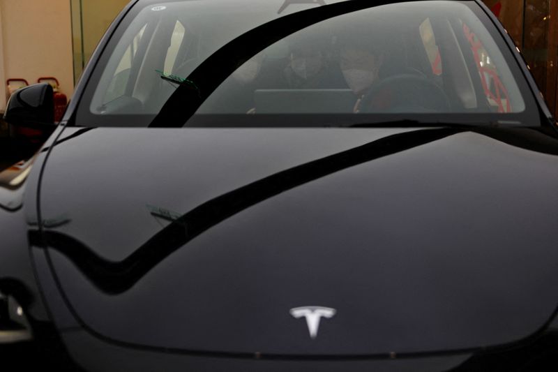 &copy; Reuters. FILE PHOTO: A staff member attends to customers inside a Tesla Model Y car at a showroom of the U.S. electric vehicle (EV) maker in Beijing, China February 4, 2023. REUTERS/Florence Lo