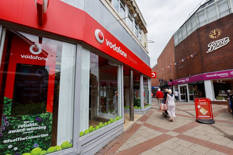 &copy; Reuters. People walk past a Vodafone store in Northwich, Cheshire, Britain, June 7, 2023. REUTERS/Jason Cairnduff/File Photo