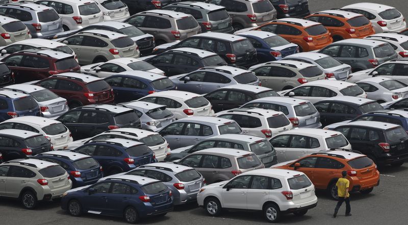 &copy; Reuters. FILE PHOTO: A worker walks beside newly produced cars ready for shipment at a port in Kawasaki, south of Tokyo May 21, 2013. REUTERS/Toru Hanai 