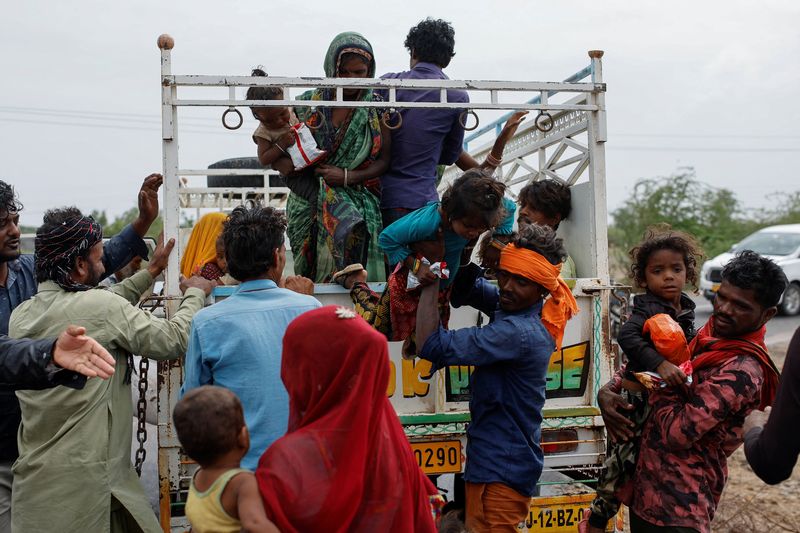 &copy; Reuters. A man carries a child from a truck during an evacuation before the arrival of cyclone Biparjoy in Jakhau in the western state of Gujarat, India, June 14, 2023. REUTERS/Francis Mascarenhas