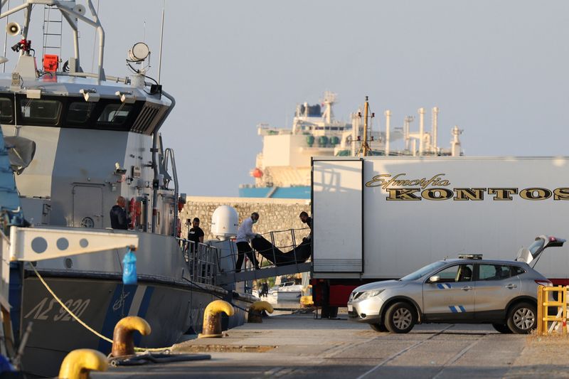 &copy; Reuters. رجال ينقلون أكياس جثث مهاجرين ماتوا بعد غرق قاربهم في عرض البحر قبالة اليونان في ميناء كالاماتا يوم الخميس. تصوير: ستيليوس ميسيناس - رويترز.
