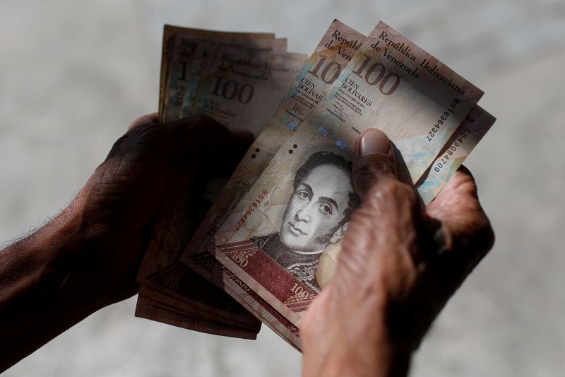 &copy; Reuters. Imagen de archivo de un hombre contando bolívares en el centro de Caracas, Venezuela. 9 enero 2018. REUTERS/Marco Bello