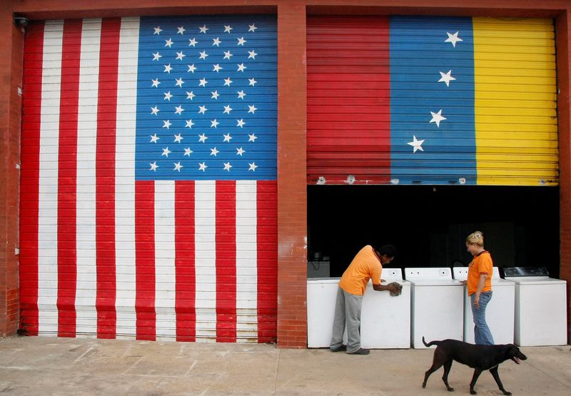 © Reuters. FILE PHOTO: Vendors prepare products at a store painted with Venezuelan and U.S. flags in Maracaibo September 12, 2008. REUTERS/Isaac Urrutia/File Photo