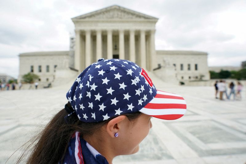 © Reuters. FILE PHOTO: A tourist wearing a patriotic cap visits the U.S. Supreme Court in Washington, U.S., June 12, 2023 REUTERS/Kevin Lamarque/File Photo