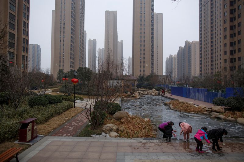 © Reuters. FILE PHOTO: People play with ice floating at a pond in the compound of an apartment complex in Zhengzhou, Henan province, China February 20, 2019. REUTERS/Thomas Peter/File Photo