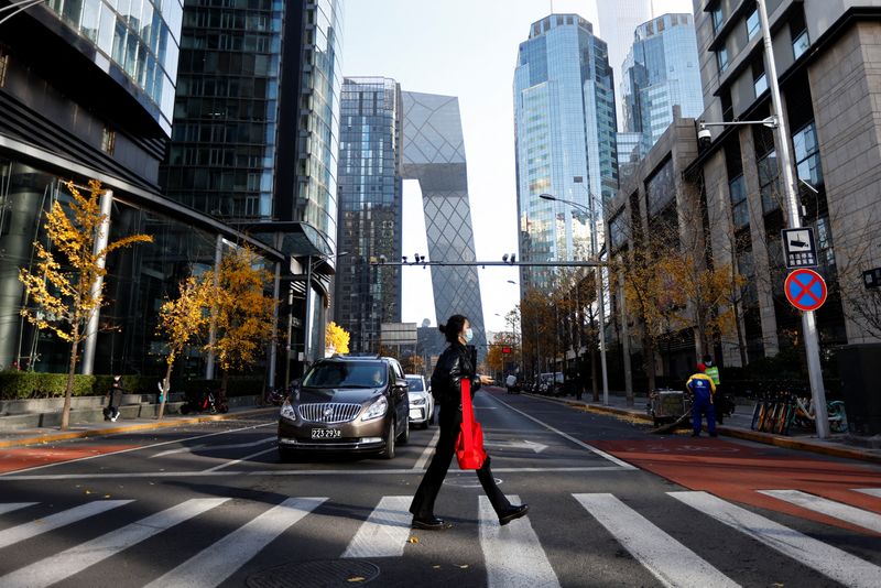 &copy; Reuters. FILE PHOTO: A woman walks across the street during morning rush hour, following the outbreak of the coronavirus disease (COVID-19), in the Central Business District (CBD) in Chaoyang District, Beijing, China November 21, 2022. REUTERS/Tingshu Wang/File Ph