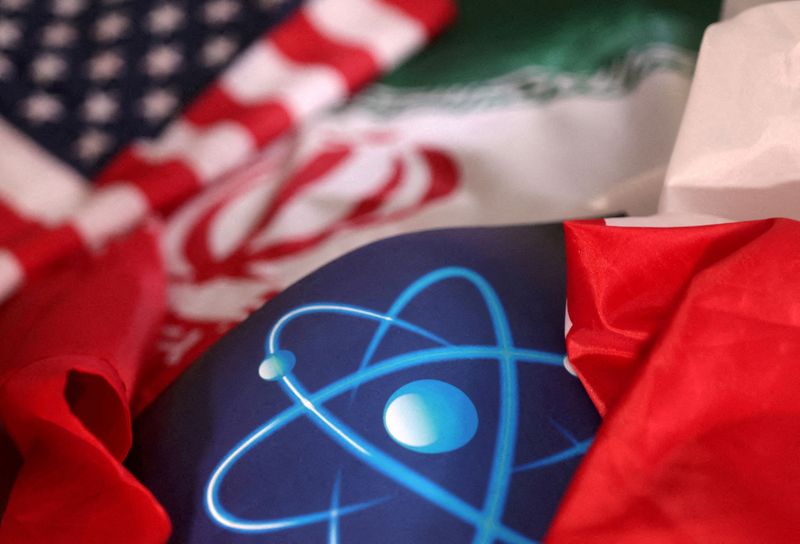 © Reuters. رمز ذري والعلمان الأمريكي والإيراني في صورة توضيحية التقطت في الثامن من سبتمبر أيلول 2022 . تصوير : دادو روفيتش - رويترز .   