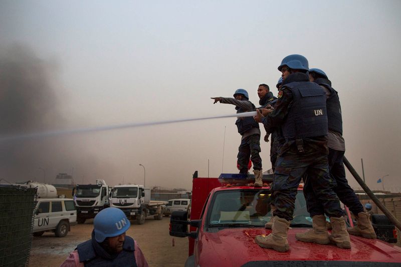 &copy; Reuters. FILE PHOTO: United Nations peacekeepers at the MINUSMA base fight fires after a mortar attack in Kidal, Mali, June 8, 2017. Picture taken June 8, 2017. MINUSMA/Sylvain Liechti/Handout via REUTERS/File Photo