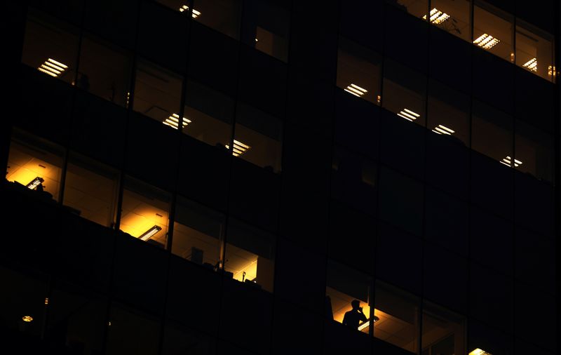 &copy; Reuters. A man talks on the phone as office lightning is seen through the windows of a building in downtown Buenos Aires, Argentina August 11, 2017. REUTERS/Marcos Brindicci