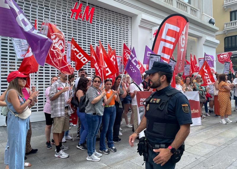 &copy; Reuters. Varias personas participan en una protesta frente a una tienda de H&M mientras los dependientes que trabajan para el minorista de moda sueco inician una huelga de tres días para exigir salarios más altos y una reducción de la carga de trabajo, en Madri
