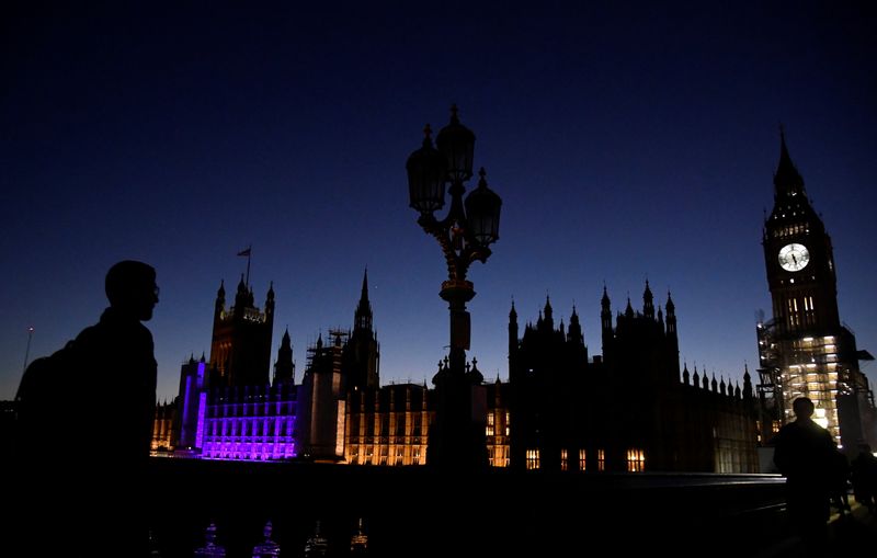 &copy; Reuters. A man crosses Westminster Bridge as the Houses of Parliament are partially illuminated in purple to commemorate Holocaust Memorial Day, London, Britain, January 27, 2022. REUTERS/Toby Melville/FILE PHOTO