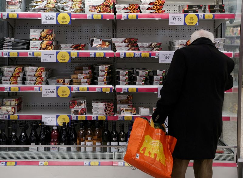 © Reuters. FILE PHOTO: A man shops next to Clubcard price branding inside a branch of a Tesco Extra Supermarket in London, Britain, February 10, 2022. Picture taken February 10, 2022. REUTERS/Paul Childs/File Photo