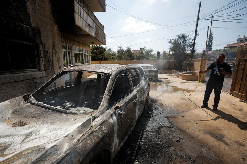 © Reuters. رجل فلسطيني يطفئ النيران المشتعلة والتي تسببت في إحراق في سيارة جراء هجوم مستوطنين إسرائيليين على بلدات فلسطينية في الضفة الغربية يوم الأربعاء . تصوير : محمد تركمان - رويترز .