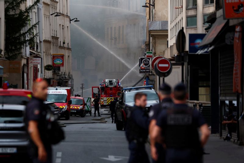 © Reuters. French police secure the area as firefighters work after several buildings on fire following a gas explosion in the fifth arrondissement of Paris, France, June 21, 2023. REUTERS/Gonzalo Fuentes