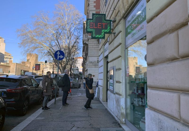 &copy; Reuters. FILE PHOTO: People queue up outside a pharmacy after a decree orders for the whole of Italy to be on lockdown in an unprecedented clampdown aimed at beating the coronavirus, in Rome, Italy, March 10, 2020. Only a limited number of people are allowed insid