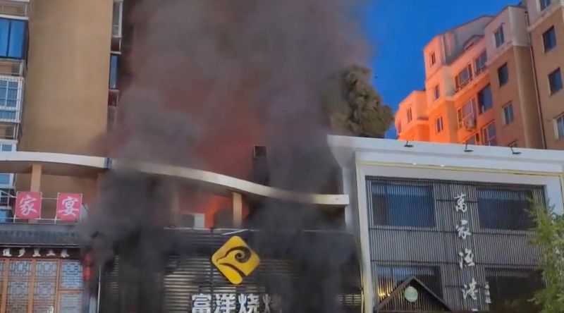 &copy; Reuters.  　中国国営・新華社通信によると、寧夏回族自治区の銀川市にある焼き肉店で６月２１日夜、ガス爆発があり、３１人が死亡した。写真は煙を上げる現場の建物。提供動画より（２０２３