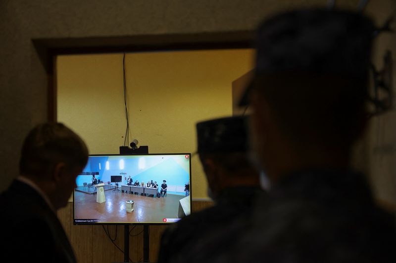 &copy; Reuters. Varias personas miran una pantalla durante una conexión de video a una audiencia externa del Tribunal de la ciudad de Moscú en un nuevo caso penal contra el político opositor ruso Alexei Navalny por numerosos cargos, incluida la creación de una organi