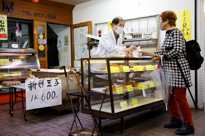 &copy; Reuters. FILE PHOTO-A customer buys food at a shop selling cooked food at a market in Tokyo, Japan, March 24, 2023. REUTERS/Androniki Christodoulou