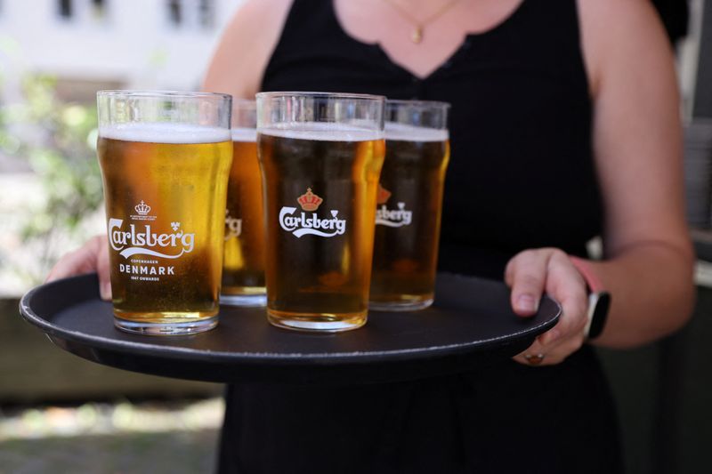 &copy; Reuters. Garçonete leva bandeija com copos de cerveja Carlsberg em Copenhague
30/07/2022
REUTERS/Andrew Kelly