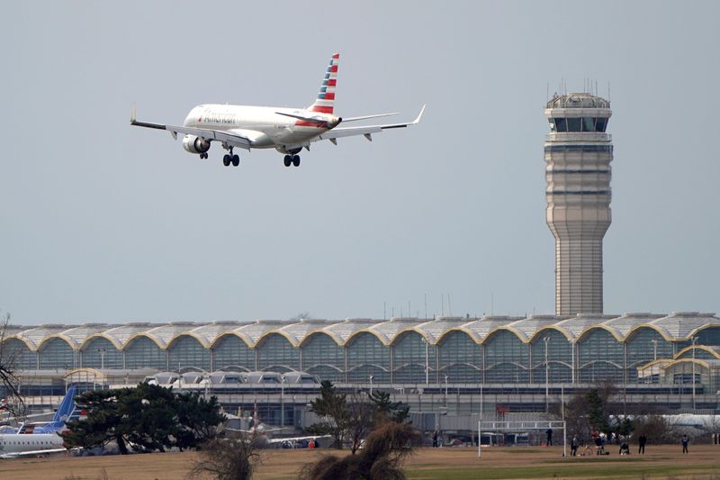 © Reuters. An American Airlines Embraer ERJ-190AR airplane flies past the tower where air traffic controllers work despite not receiving their paychecks, on the 22nd day of a partial government shutdown at Reagan National Airport in Washington, U.S., January 12, 2019. REUTERS/Joshua Roberts