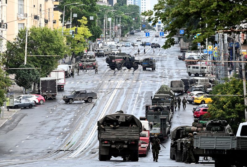 © Reuters. مقاتلون من مجموعة فاجنر العسكرية الروسية الخاصة ينتشرون في شارع قريب من مقار المنطقة العسكرية الجنوبية في روستوف أون دون يوم السبت. تصوير: رويترز.
