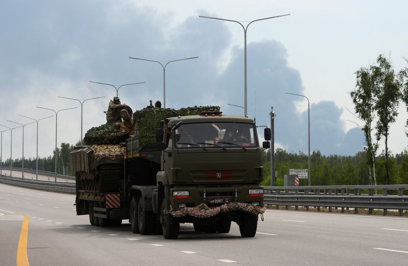 &copy; Reuters. Fighters of Wagner private mercenary group transport a tank along M-4 highway, which links the capital Moscow with Russia's southern cities, with smoke from a burning oil depot seen in the background, near Voronezh, Russia, June 24, 2023. REUTERS/Stringer