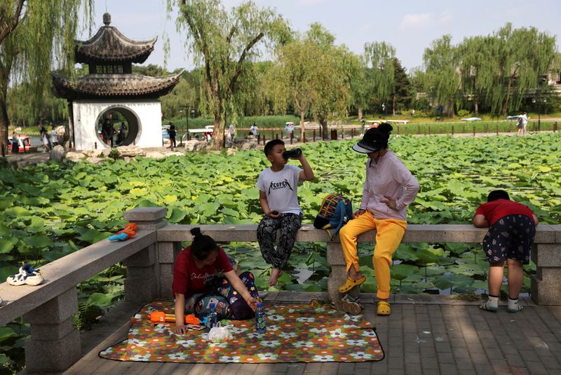 &copy; Reuters. FOTO DE ARCHIVO: Personas y niños disfrutan junto al lago en un parque durante el Festival del Barco del Dragón, tras el brote de la enfermedad por coronavirus (COVID-19), en Pekín, China. 4 de junio, 2022. REUTERS/Tingshu Wang/Archivo