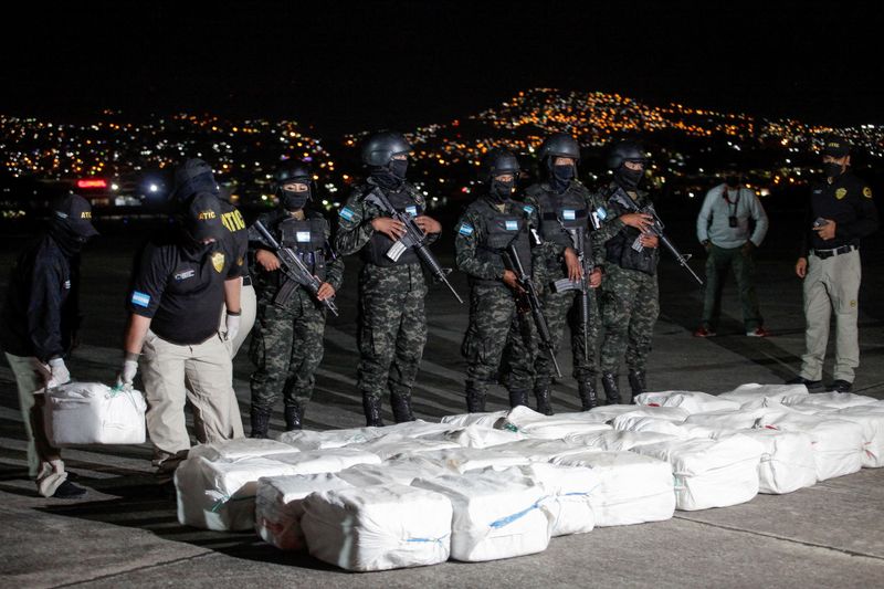 &copy; Reuters. FILE PHOTO: Officers of Honduras' Technical Agency for Criminal Investigation carry a package containing cocaine seized during a police operation, at a presentation to the media, in Tegucigalpa, Honduras December 11, 2022. REUTERS/Fredy Rodriguez