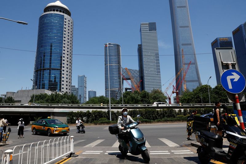 &copy; Reuters. FILE PHOTO: People ride scooters on a street at Beijing's Central Business District, in Beijing, China June 21, 2023. REUTERS/Tingshu Wang