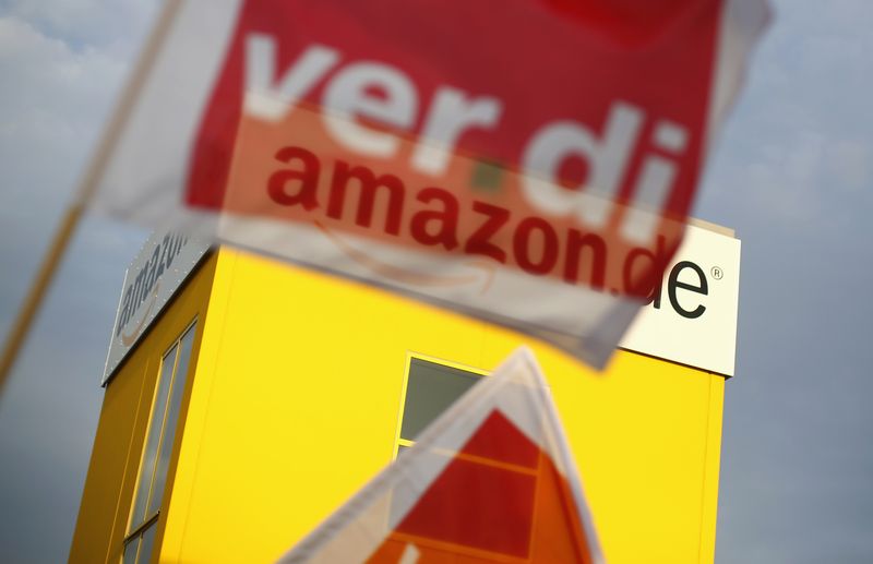 &copy; Reuters. FILE PHOTO: A flag of German united services union Ver.di is pictured in front of the logo of Amazon on a warehouse in Bad Hersfeld May 14, 2013. REUTERS/Lisi Niesner  