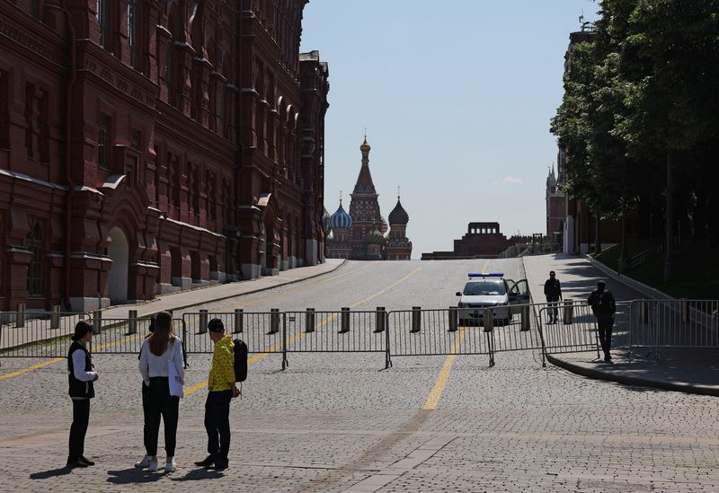 &copy; Reuters. أشخاص يقفون بالقرب من الساحة الحمراء المغلقة في موسكو يوم الأحد. تصوير: إيفجينيا نوفوزينينا - رويترز.
