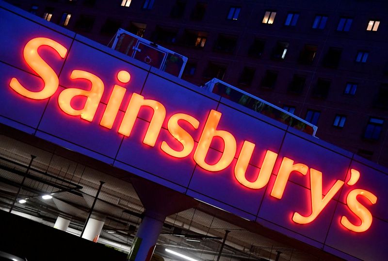© Reuters. FILE PHOTO: Illuminated signage is seen at a branch of the Sainsbury's supermarket in London, Britain, January 7, 2022. REUTERS/Toby Melville/File Photo