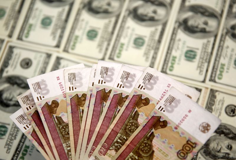 &copy; Reuters. Banconote da 100 rubli e banconote da 100 dollari statunitensi.  REUTERS/Dado Ruvic 