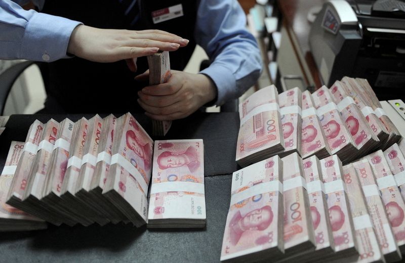 © Reuters. FILE PHOTO: An employee counts 100 Chinese yuan banknotes at a bank in Hefei, Anhui province, January 21, 2013.   REUTERS/Stringer/File Photo