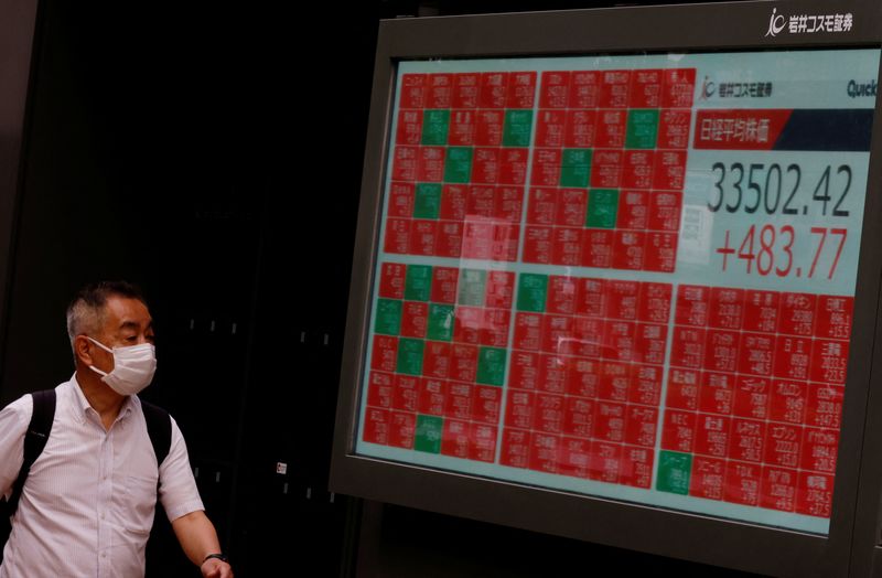 &copy; Reuters.  رجل ينظر إلى شاشة إلكترونية تعرض بيانات مؤشر نيكي الياباني خارج شركة للوساطة المالية في طوكيو يوم 14 يونيو حزيران 2023. تصوير: كيم كيونج هوون –