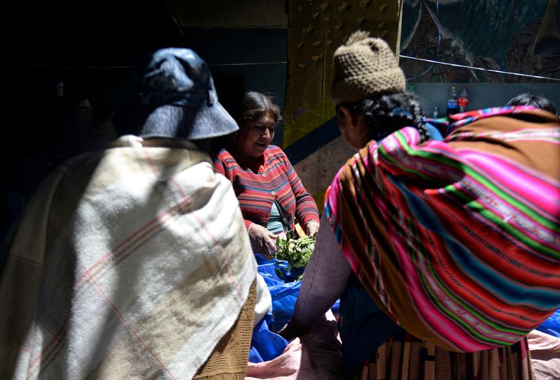 &copy; Reuters. Imagen de archivo de una vendedora de coca mostrando su producto a unos compradores en un mercado de La Paz, Bolivia. 10 octubre 2022. REUTERS/Claudia Morales