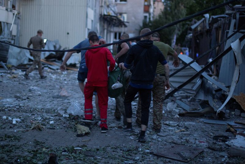 &copy; Reuters. متطوعون يحملون جريحا في موقع مباني فنادق ومطاعم تضررت بشدة جراء هجوم صاروخي روسي في وسط كراماتورسك بمنطقة دونيتسك بأوكرانيا يوم الثلاثاء. ت