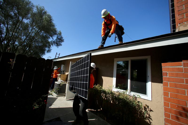 &copy; Reuters. FILE PHOTO: Workers lift a solar panel onto a roof during a residential solar installation in Scripps Ranch, San Diego, California, U.S. October 14, 2016. Picture taken October 14, 2016. REUTERS/Mike Blake//File Photo