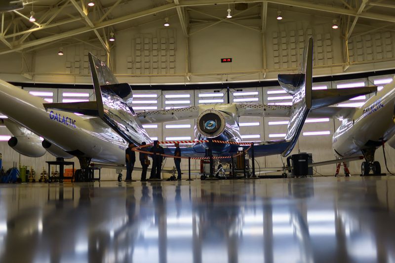 © Reuters. People stand near the passenger rocket plane, operated by Virgin Galactic, one day before the company's first commercial flight to the edge of space, at the Spaceport America facility, in Truth or Consequences, New Mexico, U.S., June 28, 2023. REUTERS/Jose Luis Gonzalez