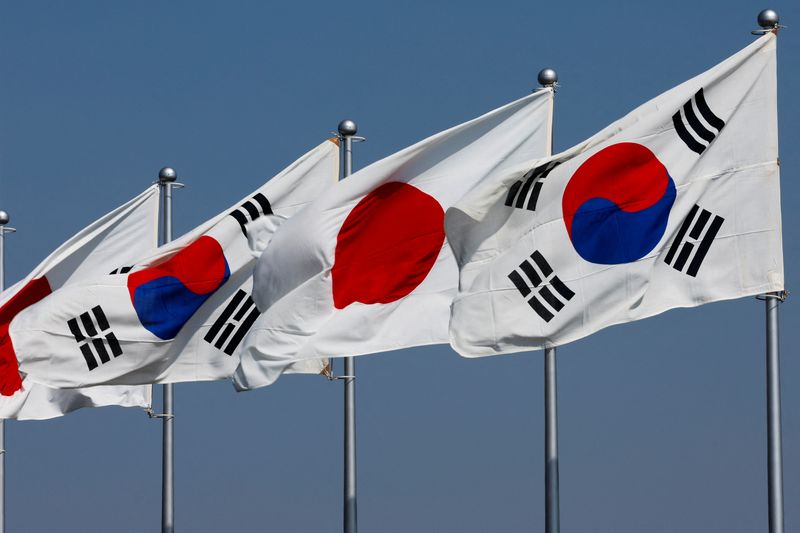 © Reuters. A view of South Korean and Japanese national flags hoisted ahead of the arrival of South Korea's President Yoon Suk Yeol and his wife Kim Keon-hee, at Tokyo International Airport (Haneda Airport) in Tokyo, Japan March 16, 2023.   REUTERS/Issei Kato