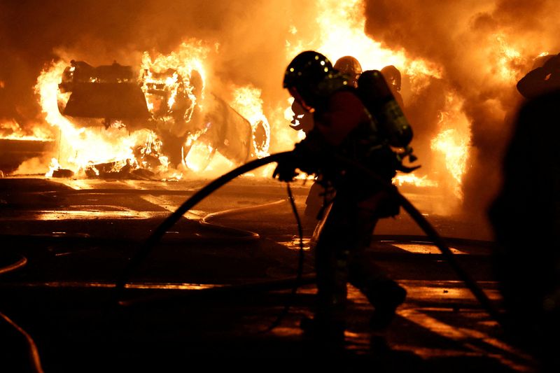 &copy; Reuters. Des pompiers éteignent des véhicules en feu lors d'affrontements entre des manifestants et des policiers, après la mort de Nahel, un adolescent de 17 ans tué par un policier ors d'un contrôle routier, à Nanterre, dans la banlieue parisienne, en Fran