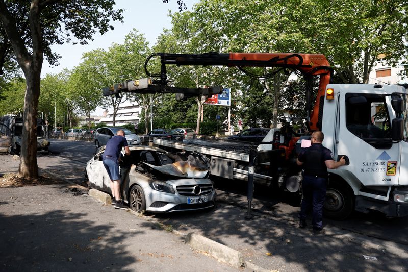 &copy; Reuters. Une voiture, incendiée lors d'affrontements entre des jeunes et des policiers, est retirée de la rue au lendemain de la mort d'un adolescent de 17 ans tué par un policier lors d'un contrôle routier, à Nanterre, dans la banlieue parisienne, en France.