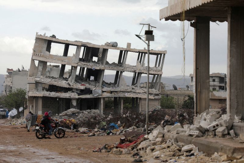 &copy; Reuters.  أشخاص يركبون دراجة نارية أمام مبان تضررت جراء الزلزال الذي ضرب سوريا في السادس من فبراير شباط في بلدة جندريس بسوريا يوم 29 مارس آذار 2023. تصوي