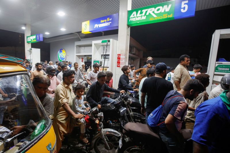 © Reuters. FILE PHOTO: People wait their turn to get fuel at a petrol station, in Karachi, Pakistan June 2, 2022.  REUTERS/Akhtar Soomro/File Photo